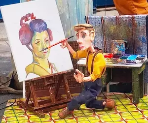 古巴藝術家Victor Ariosa的《小木偶操縱畫》，不是畫家執筆而是讓木偶拿筆繪圖的表演藝術