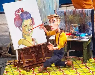 古巴藝術家Victor Ariosa的《小木偶操縱畫》，不是畫家執筆而是讓木偶拿筆繪圖的表演藝術